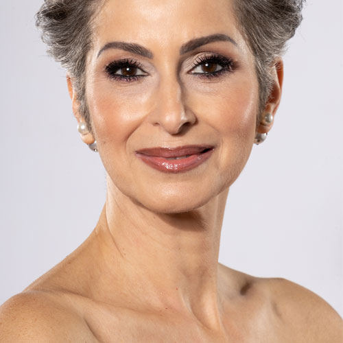 Ältere, geschminkte Frau mit grauen Haaren im Portrait